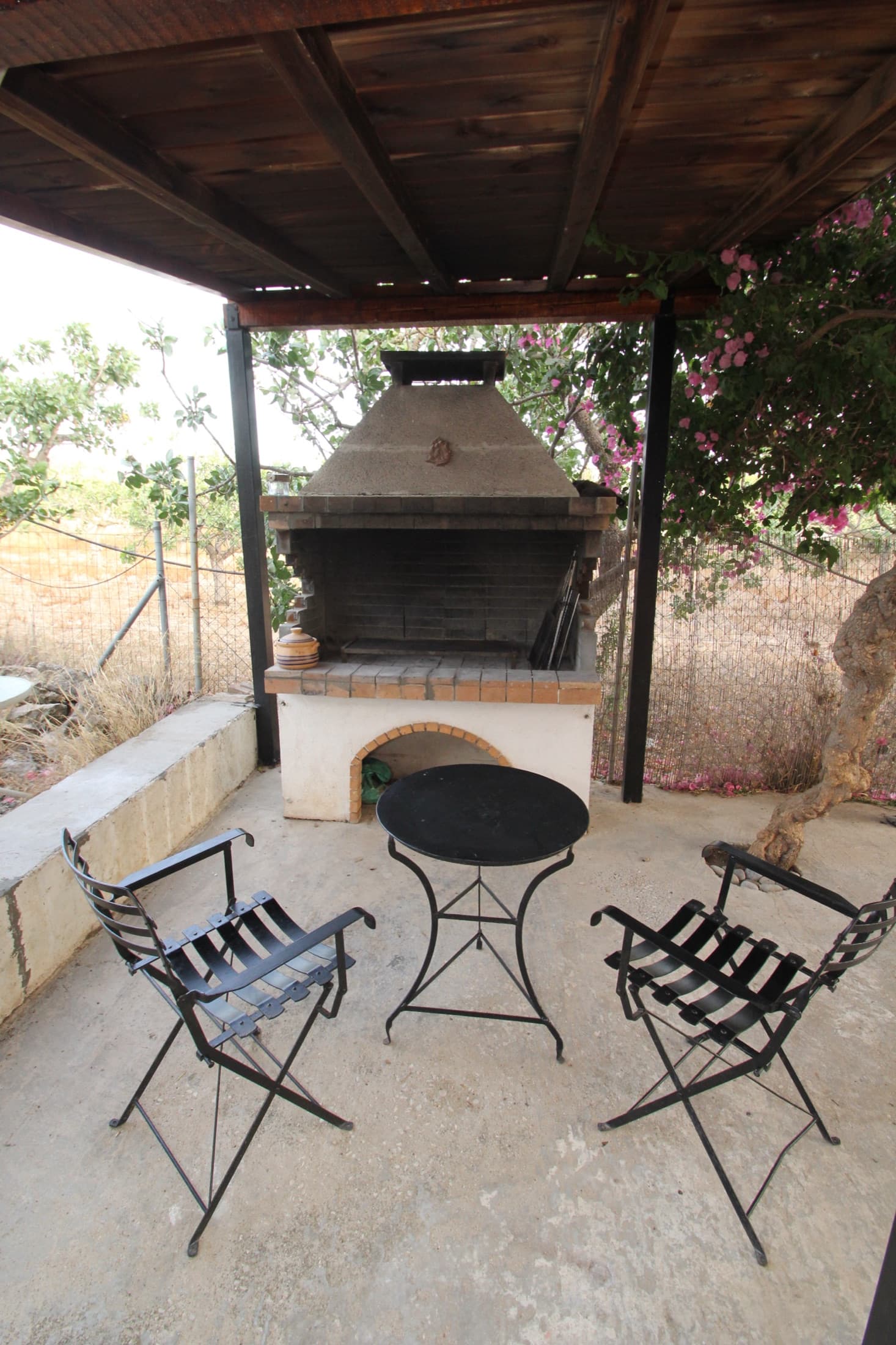Traditional stone barbecue on the shaded terrace at Fistiki House