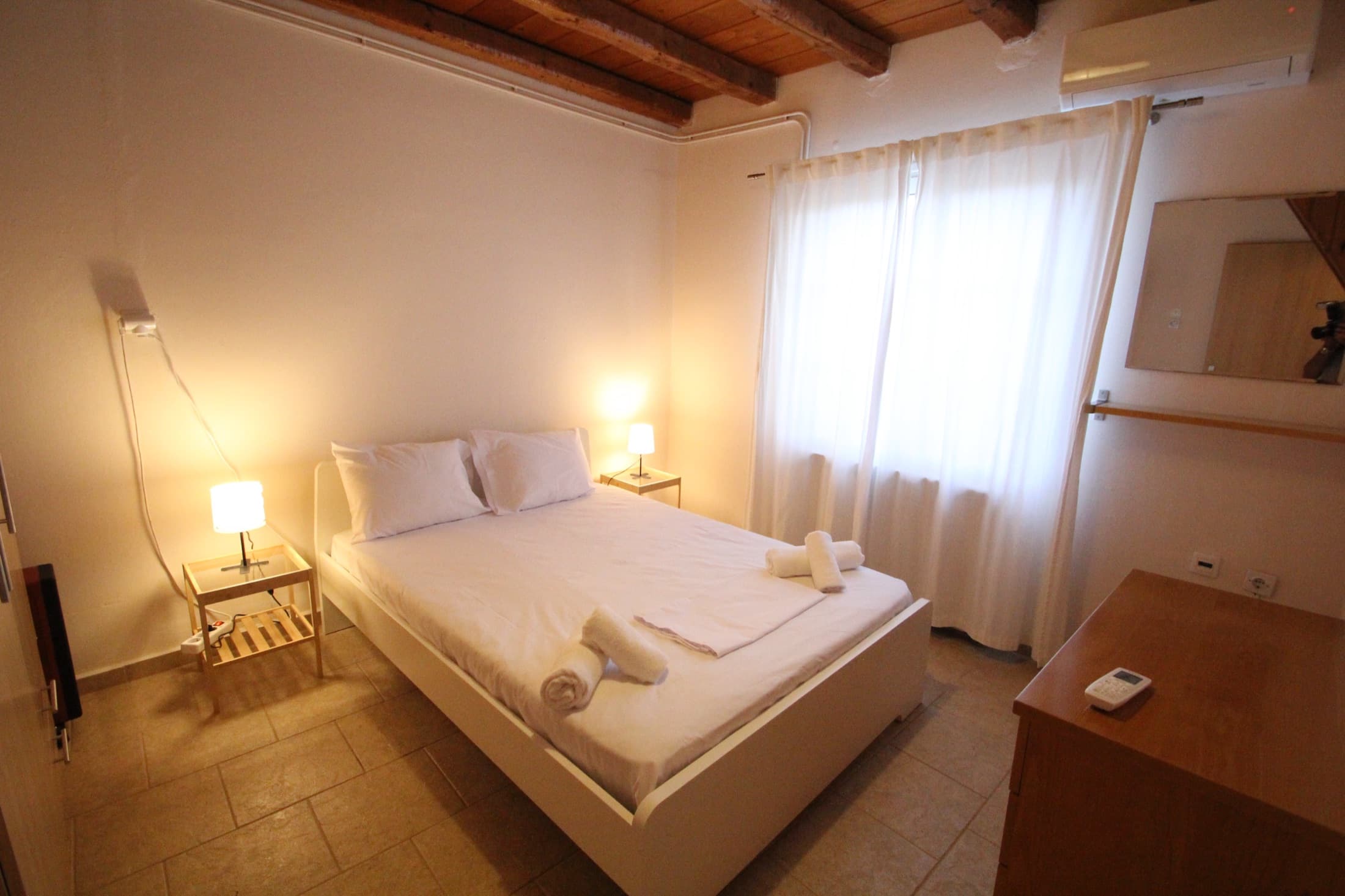 Double bedroom with exposed wooden beams at Fistiki House