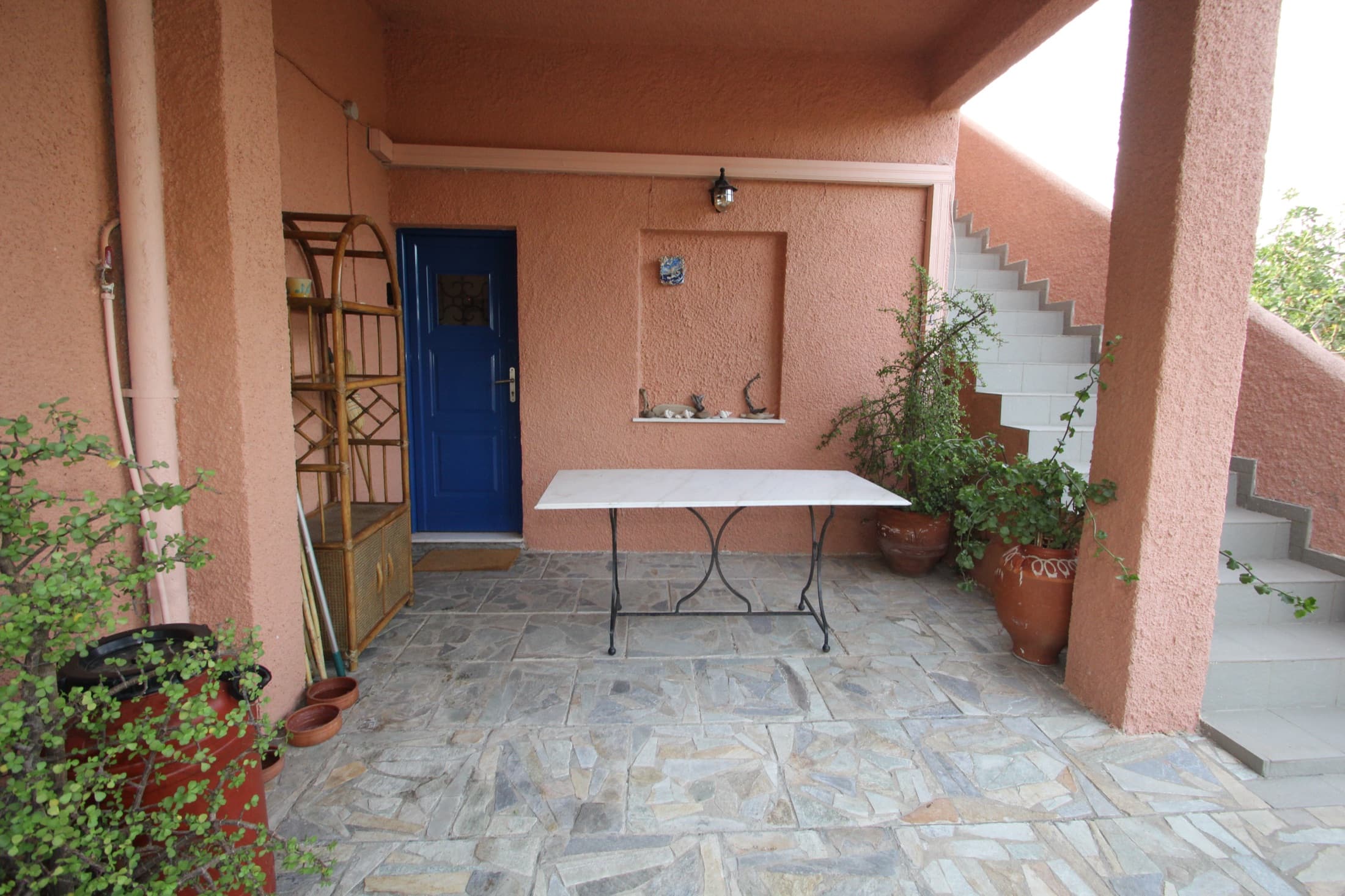 Entrance courtyard of Fistiki House with its blue door