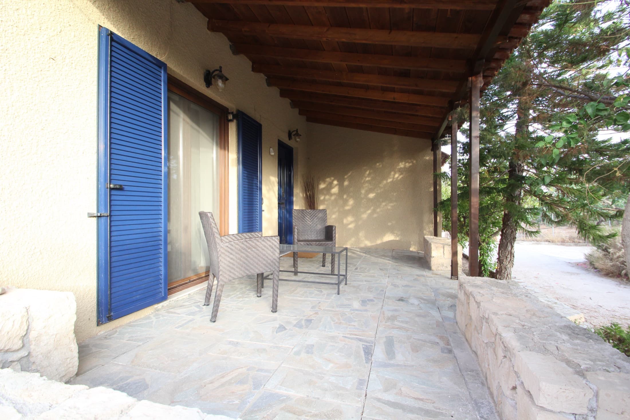 Shaded veranda with blue shutters at Fistiki House